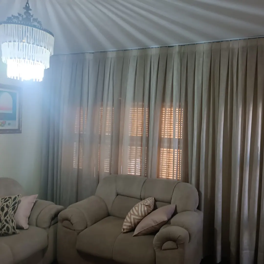 Cortina vual com reposteiro cinza em sala
